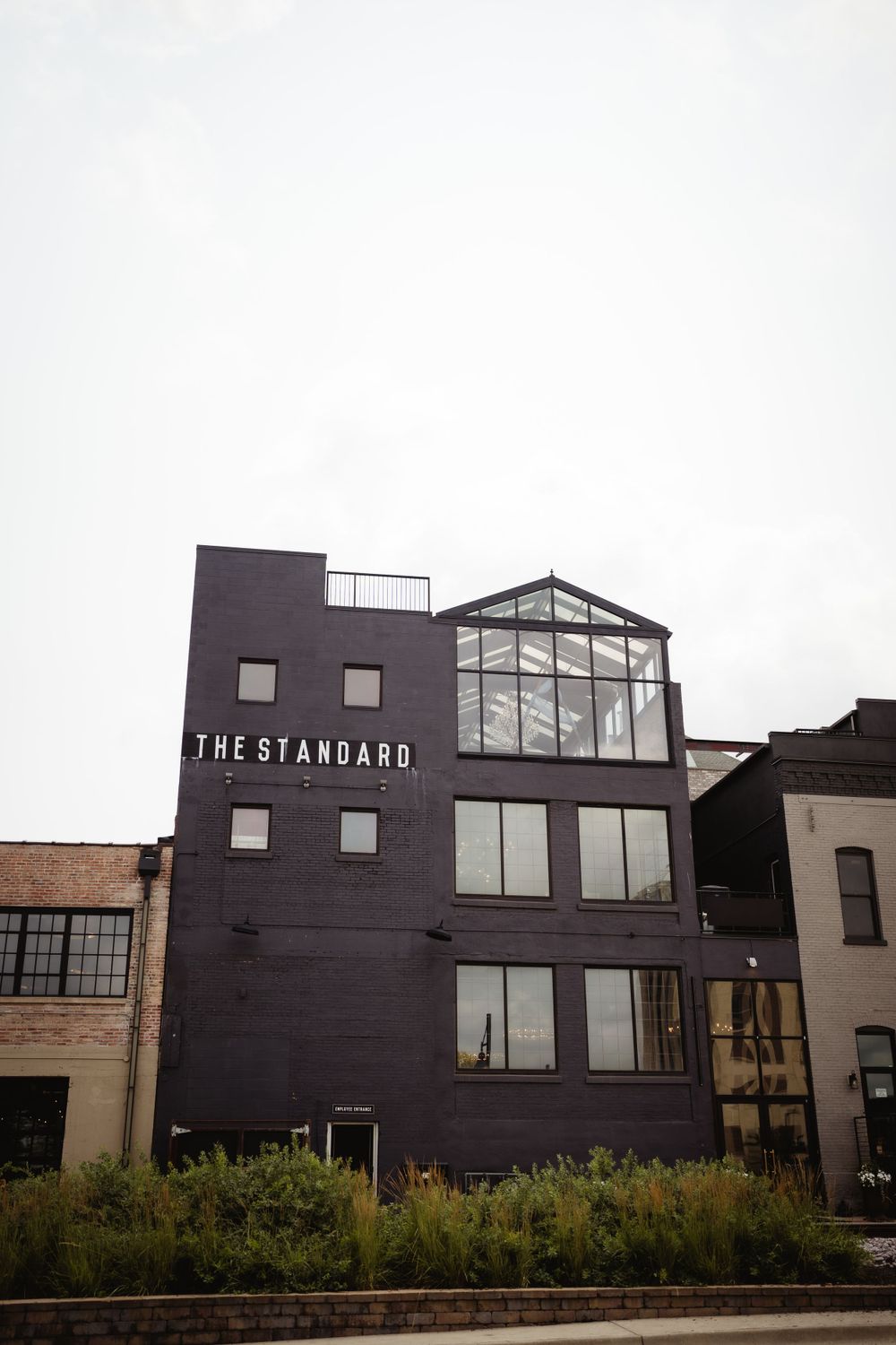 Modern purple building exterior with 'The Standard' signage and glass top floor.