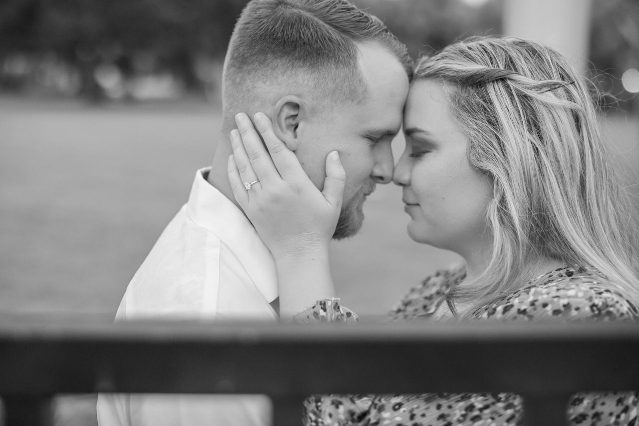 Intimate black and white portrait of couple sharing tender moment outdoors.