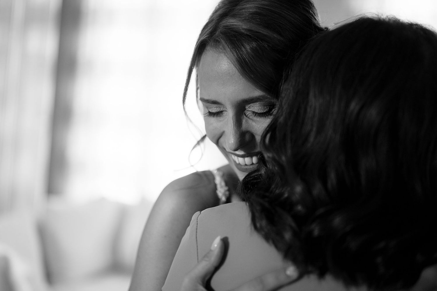 A candid black and white photo capturing an emotional wedding day moment.