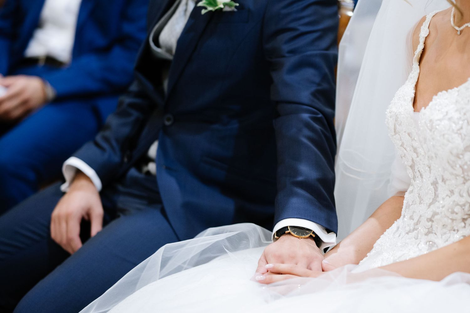 Close-up view of a bride and groom sitting together during their wedding ceremony.