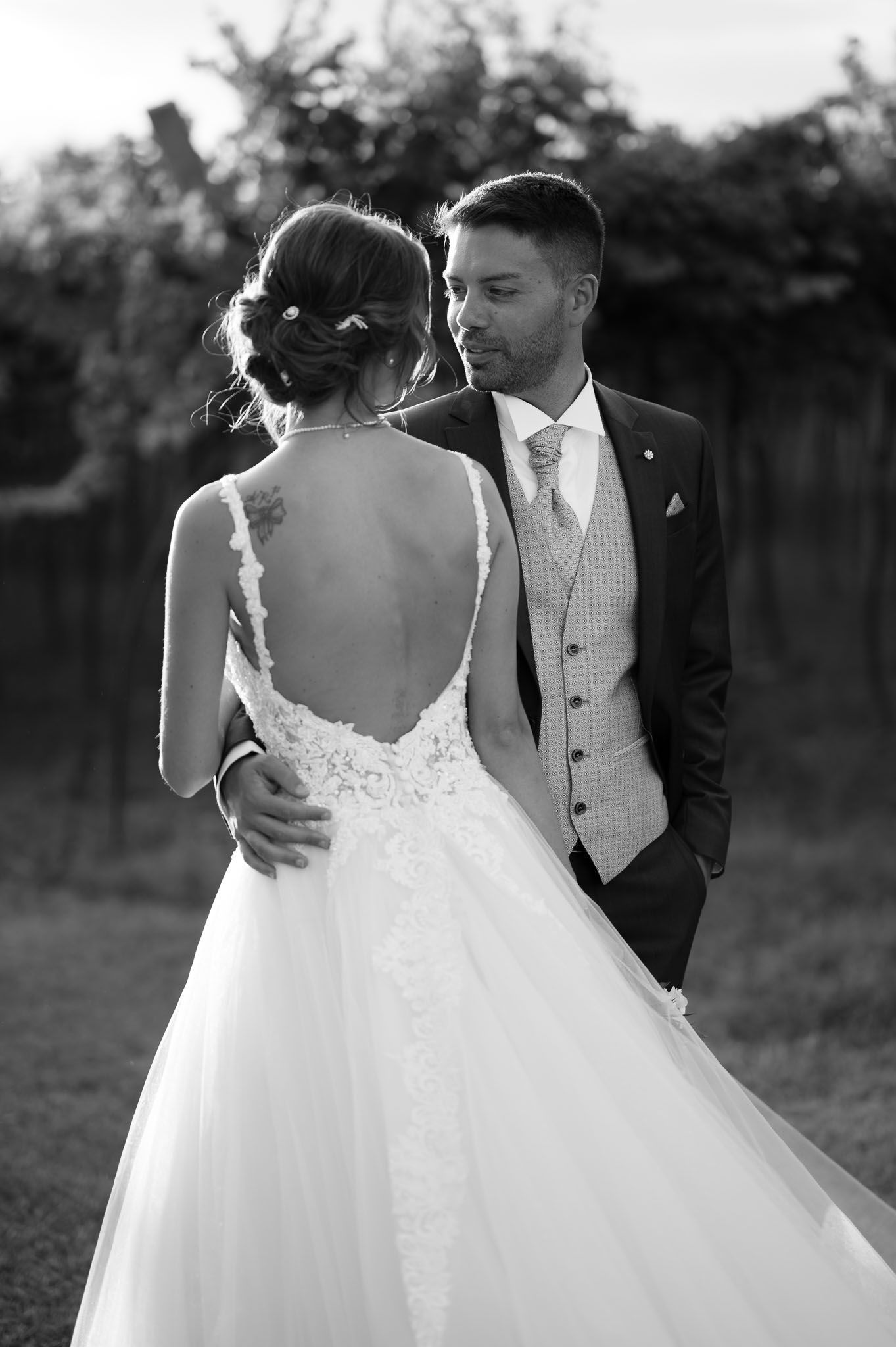 Intimate black and white portrait showcasing bride's lace back wedding dress.
