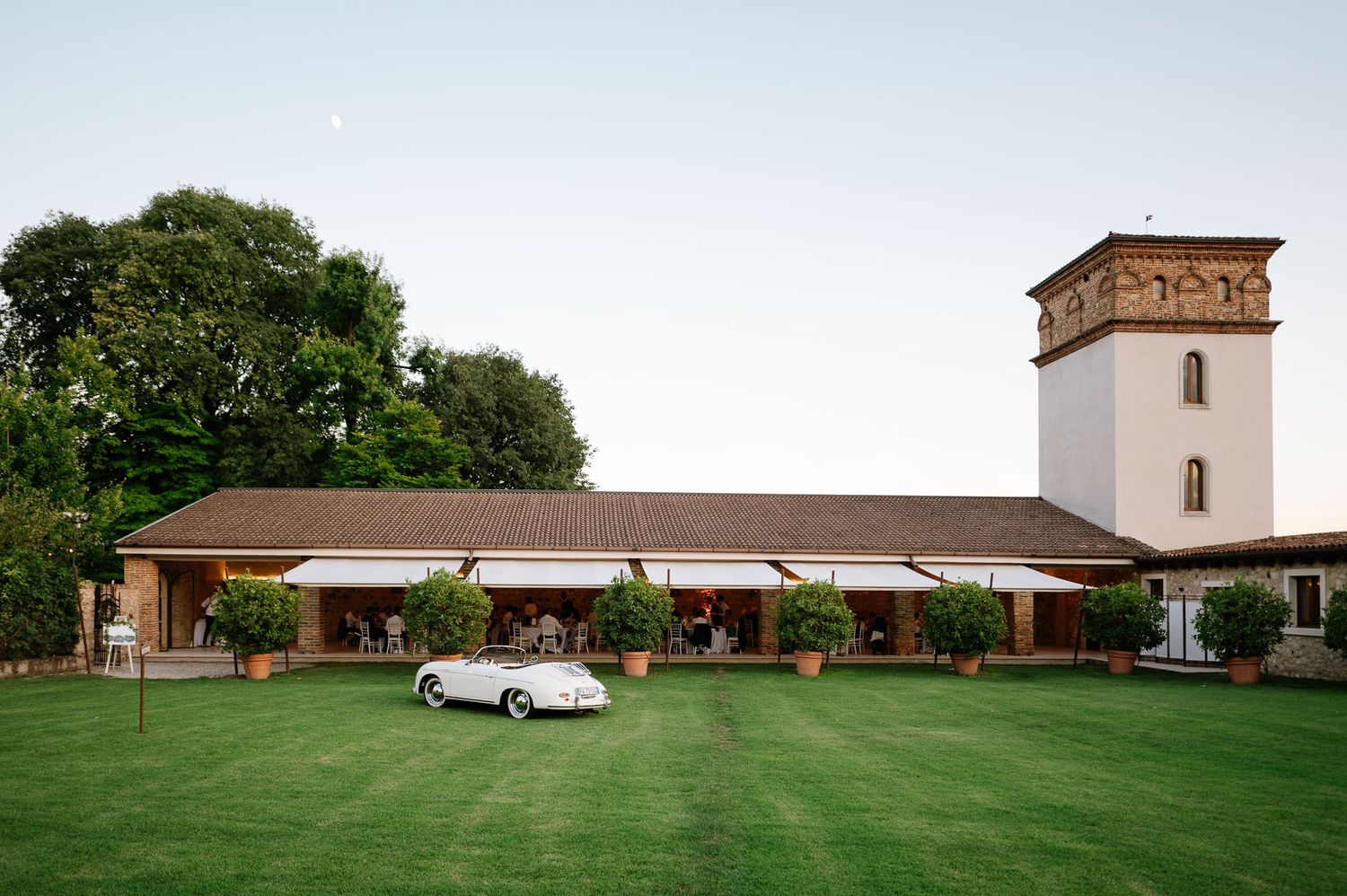 An elegant venue with Spanish-style architecture and manicured lawn at dusk.