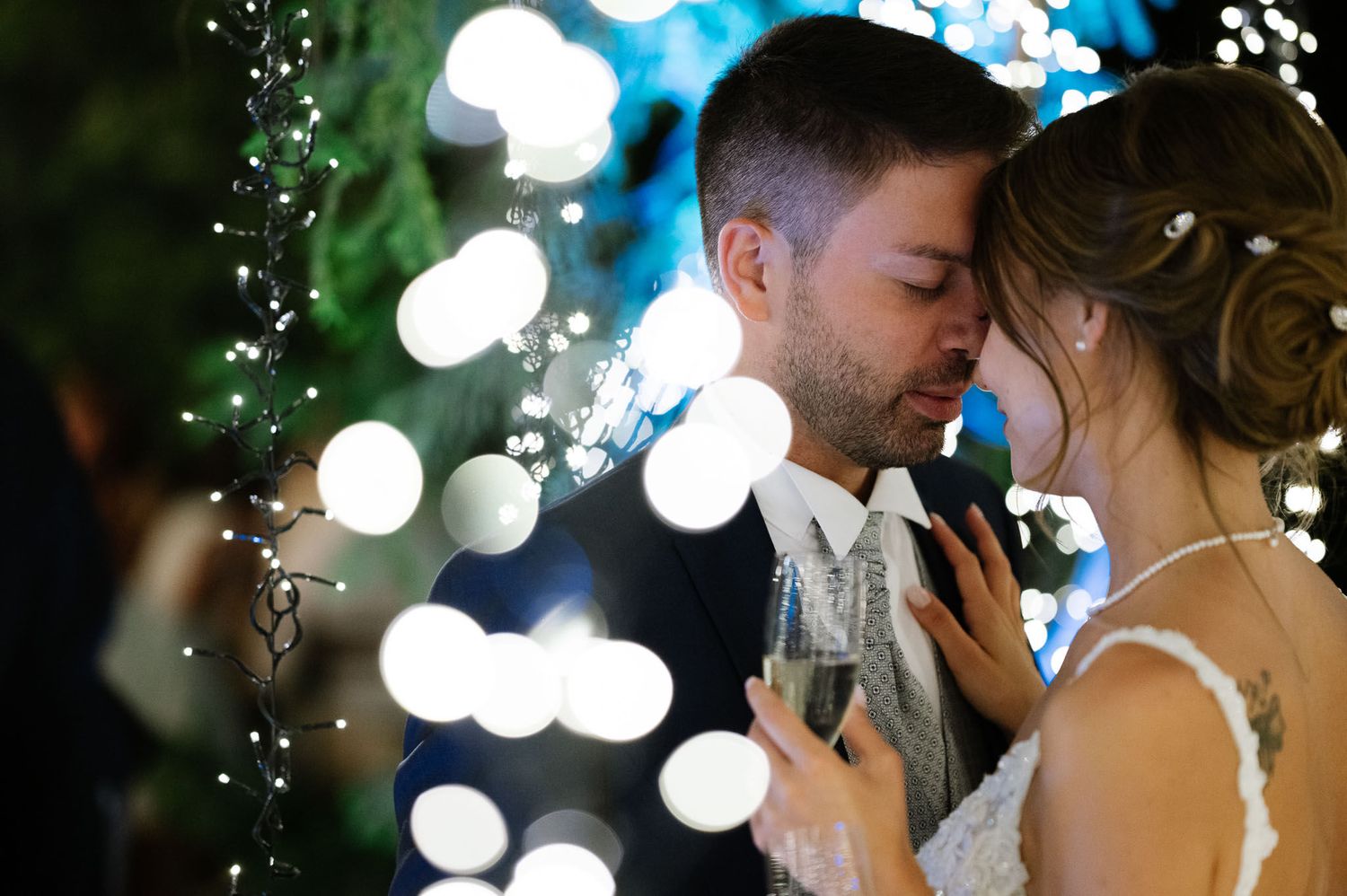Romantic wedding moment with twinkling bokeh lights creating a dreamy atmosphere during an evening celebration.