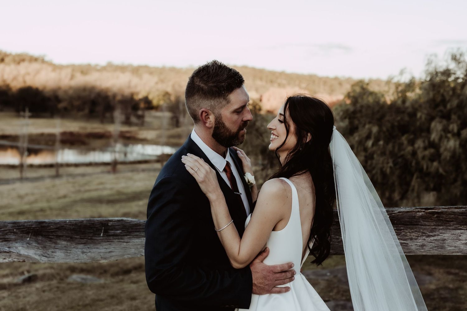 Romantic sunset wedding photos of couple embracing outdoors.