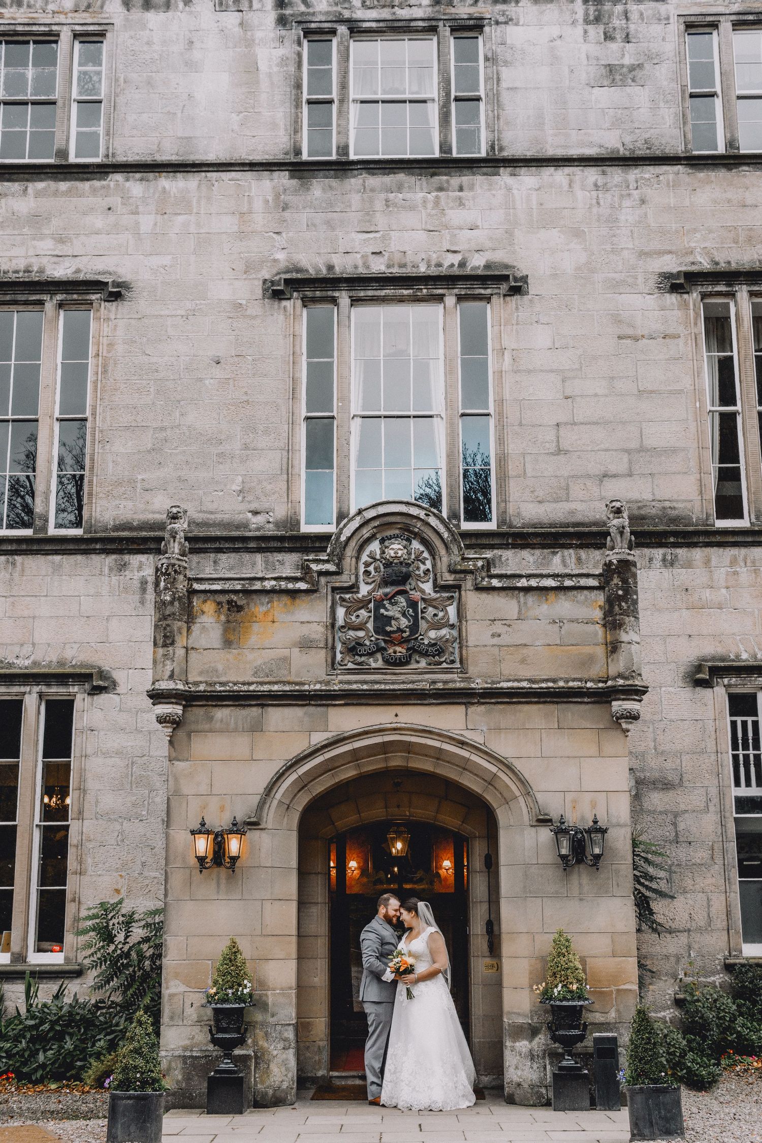 a bride and groom standing in the entrance to a castle in Scotland where they eloped