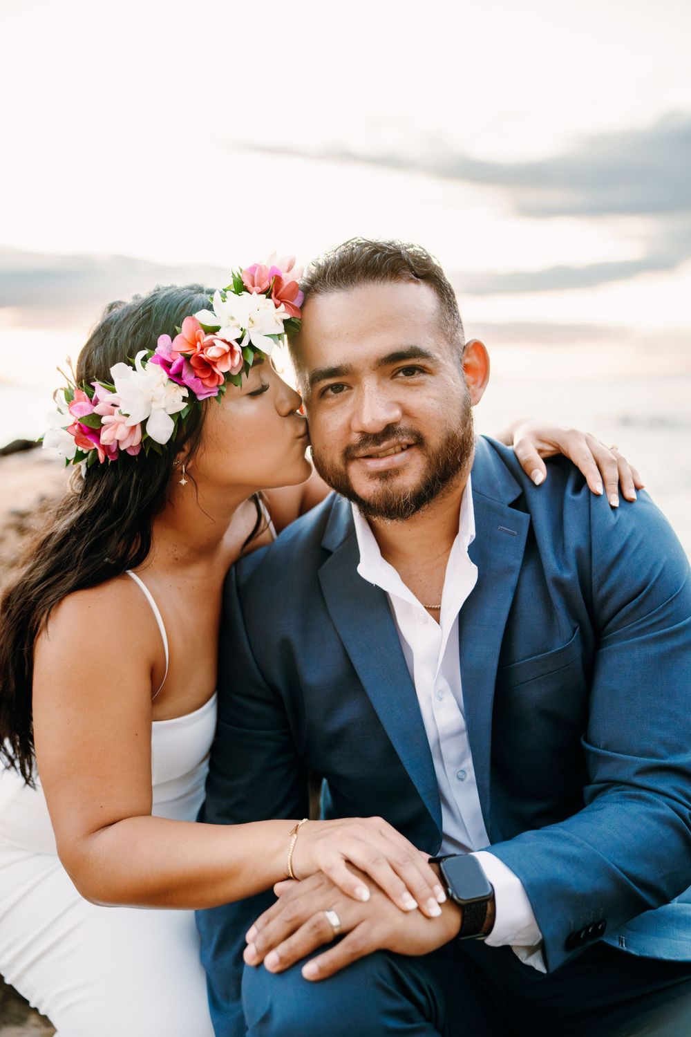 Romantic couple sharing intimate moment on beach during sunset.