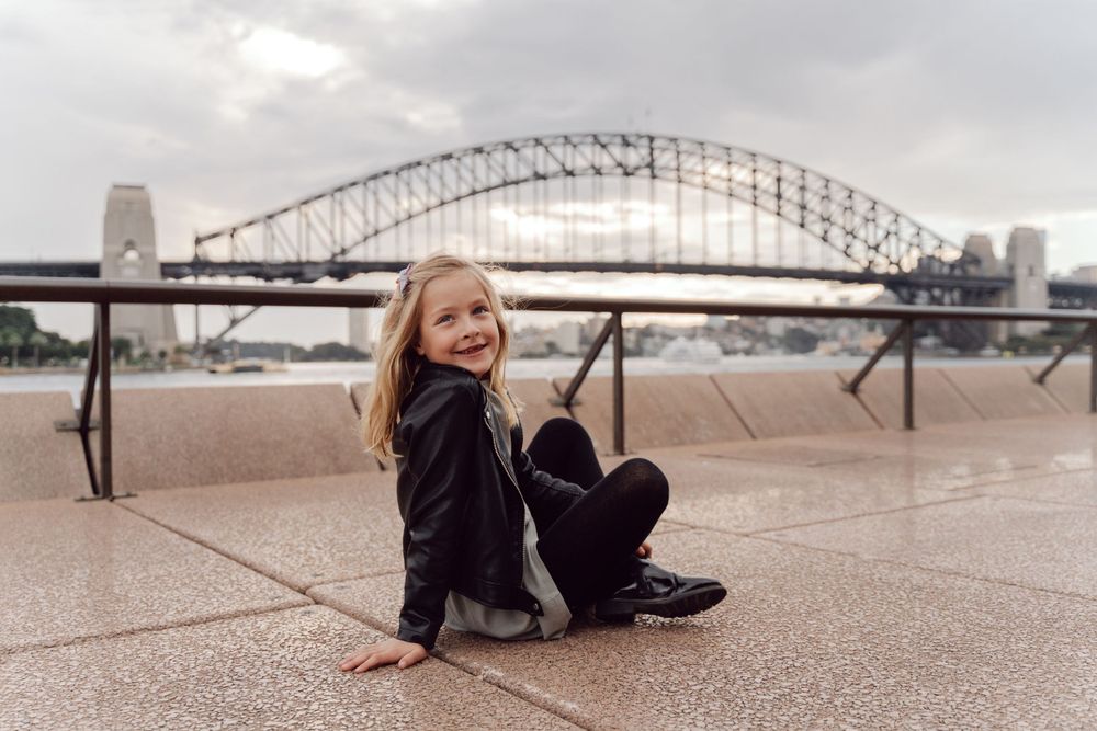 girl in front of a harbour bridge during a photoshoot