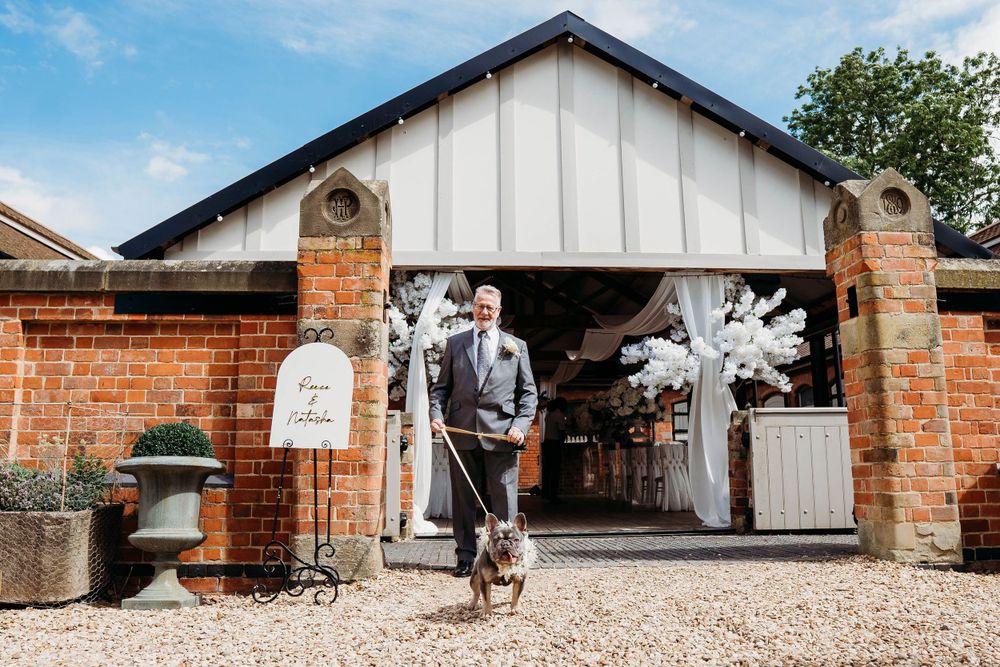 Wedding venue entrance decorated with white florals and rustic brick pillars.