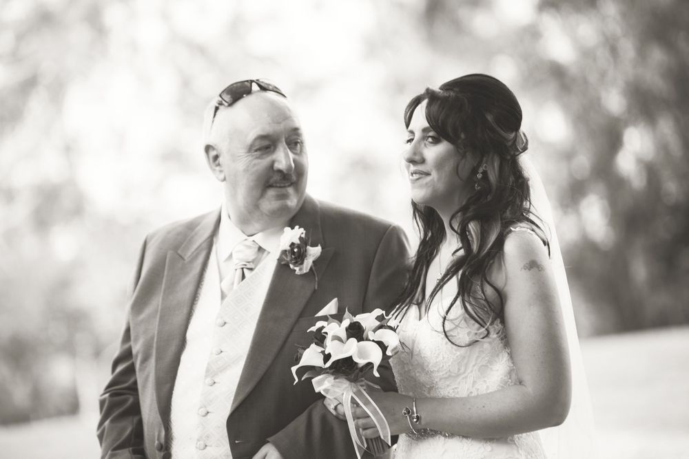 A black and white wedding portrait captured during an emotional moment outdoors.