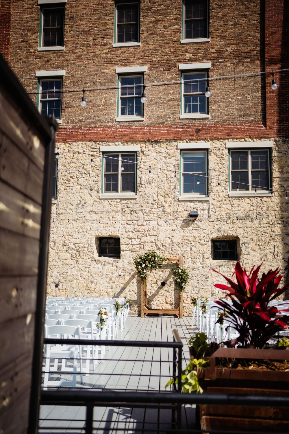 Historic brick building exterior with white stone base and decorated wedding ceremony space.