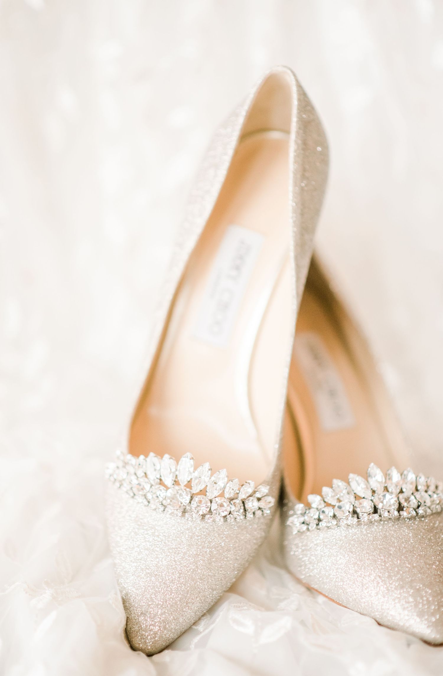 Sparkly silver bridal shoes with crystal embellishments against white fabric. Indianapolis, Indiana. Angela Hartwig Photography.