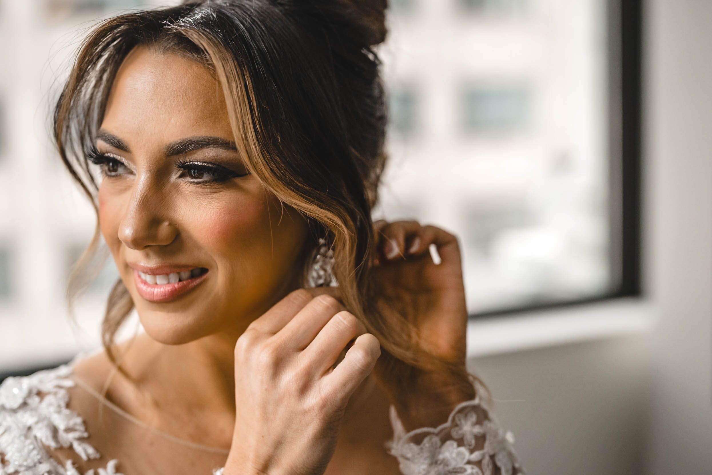 Close up detail of delicate lace wedding dress sleeve and jewelry.