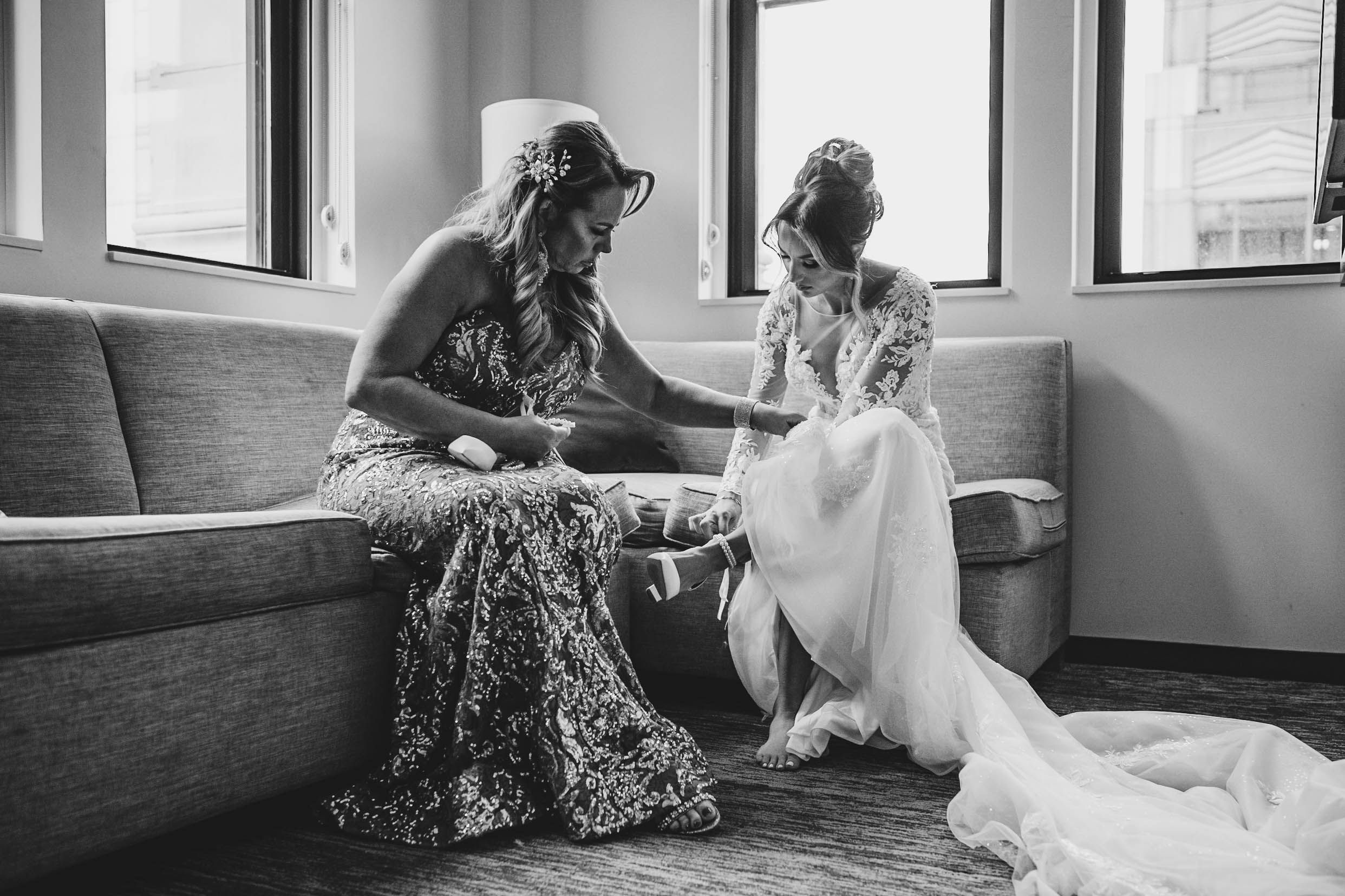 Natural light streams through windows during intimate wedding preparation moment.