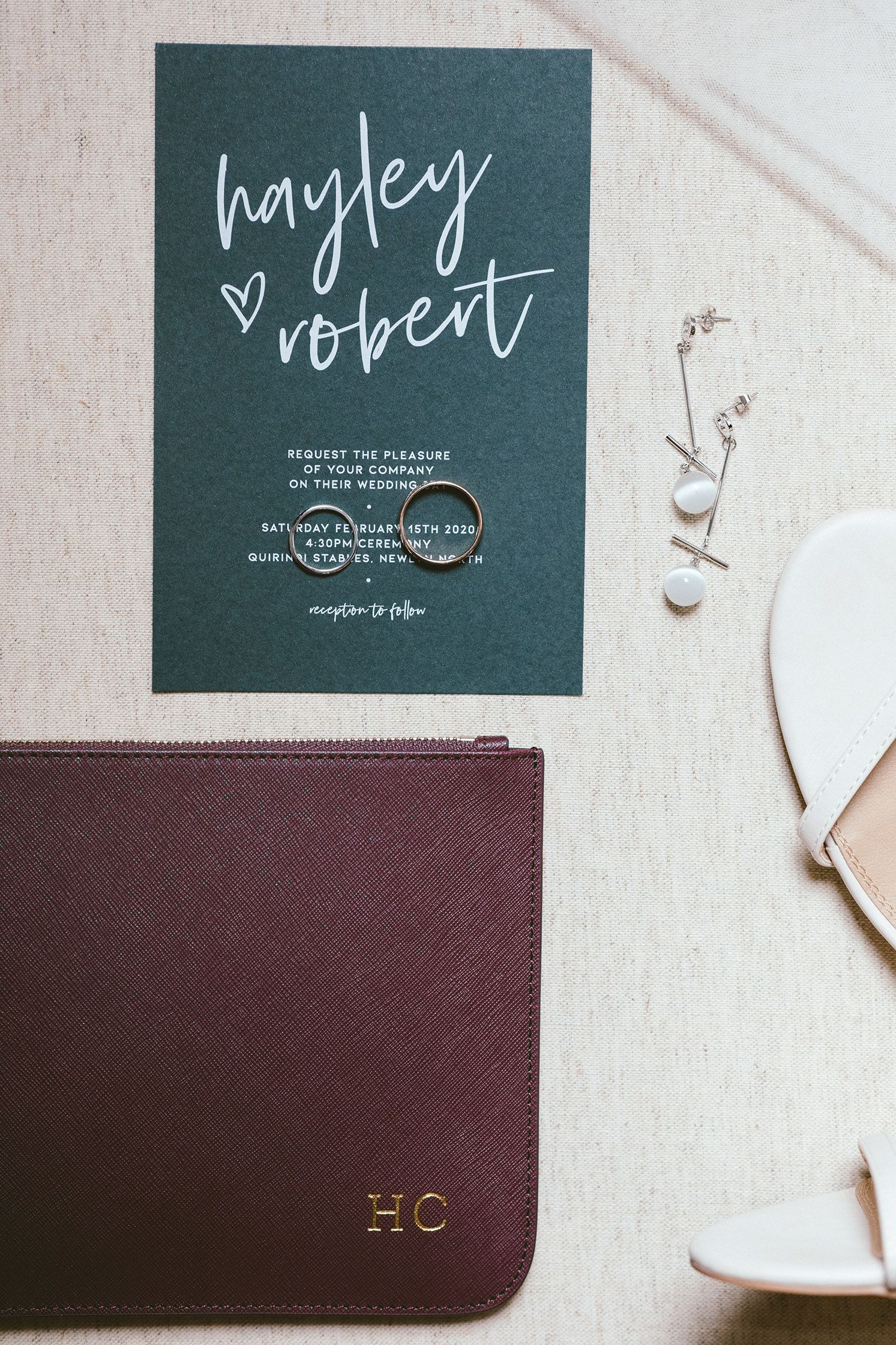 Wedding invitation with elegant calligraphy on dark green paper.