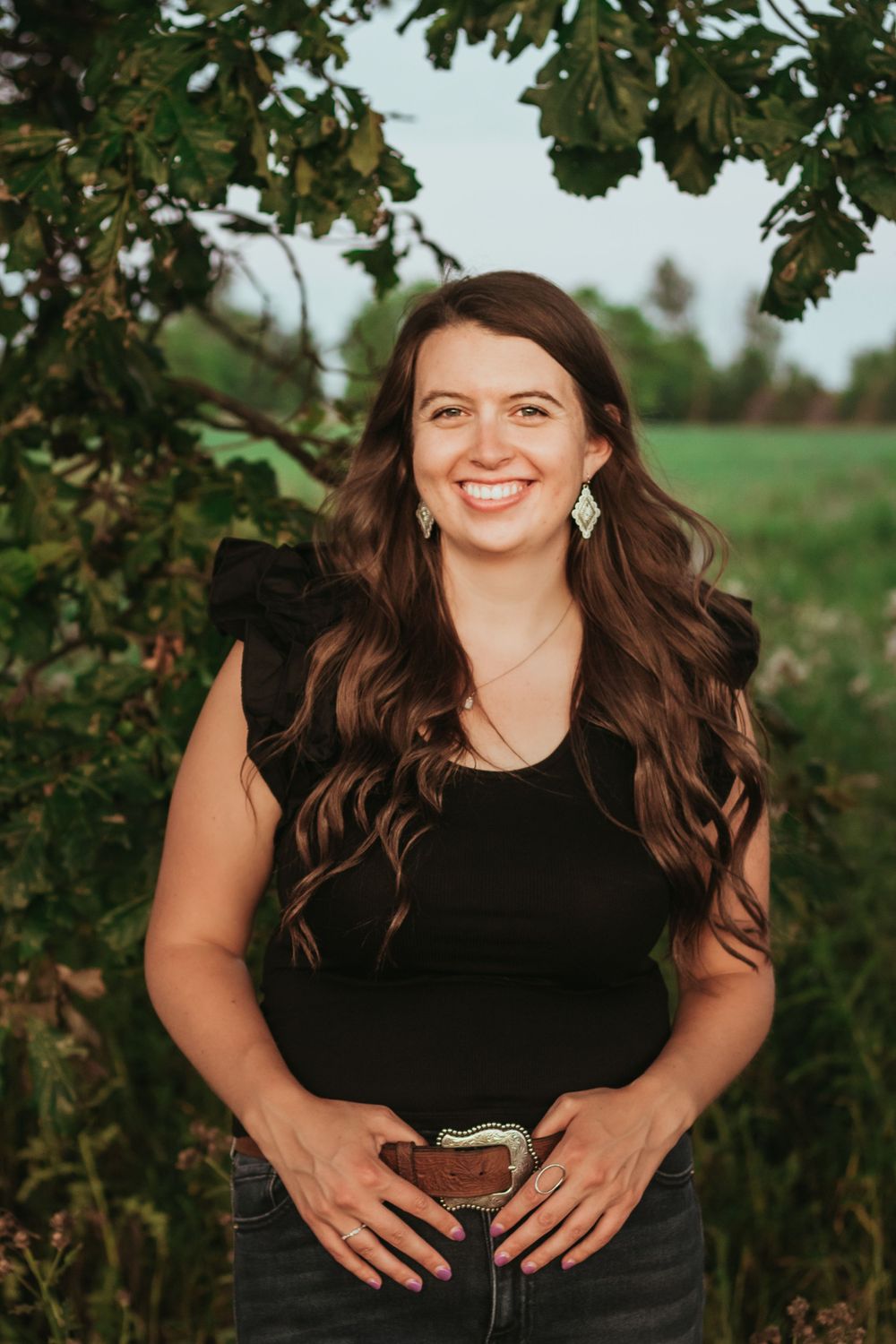 Portrait under oak tree branches in natural outdoor setting.
