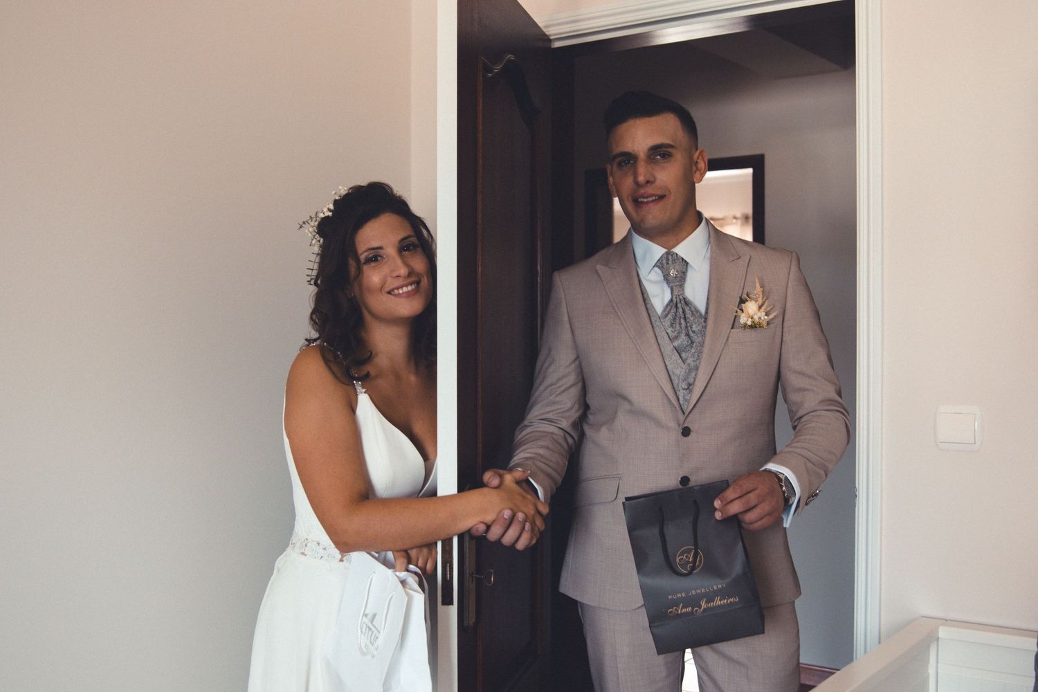 Wedding couple in formal attire pose in doorway before ceremony.