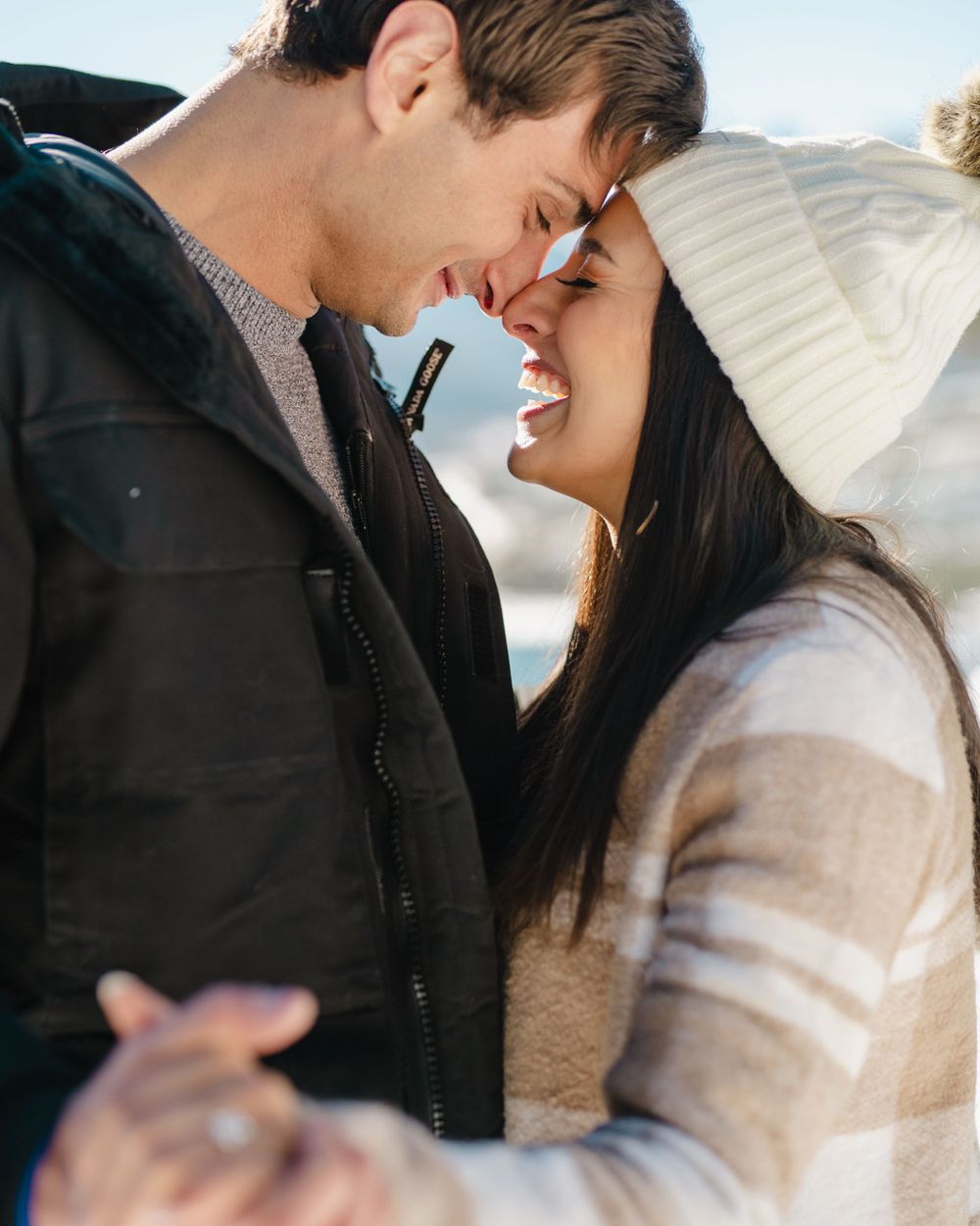 A romantic winter moment shared between two people in warm clothing.