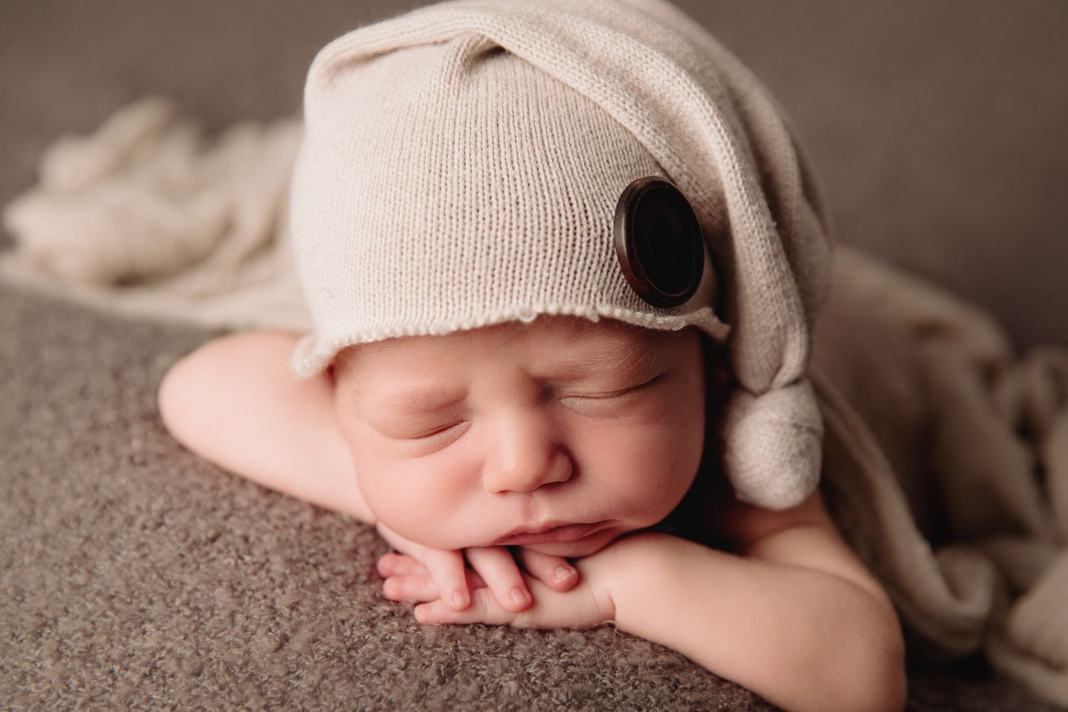 baby boy sleeping grey blanket with knit hat on