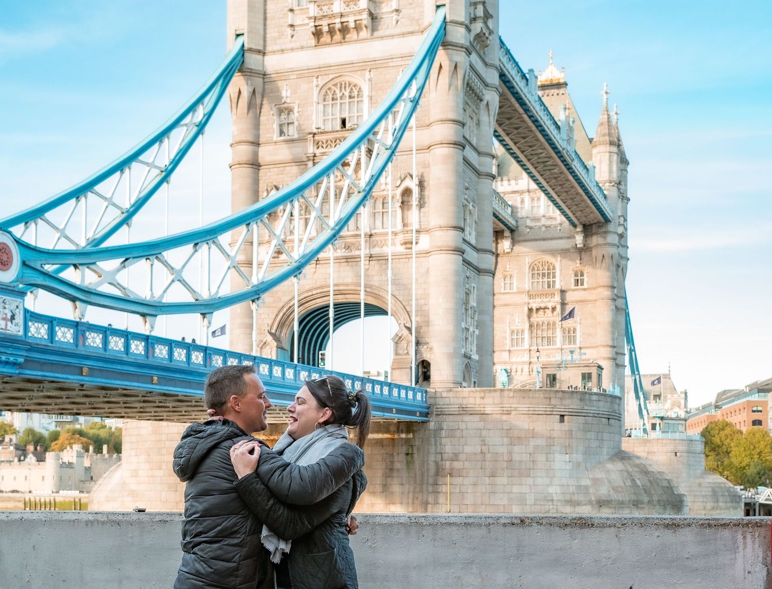 A couple embraces in front of London's iconic Tower Bridge.