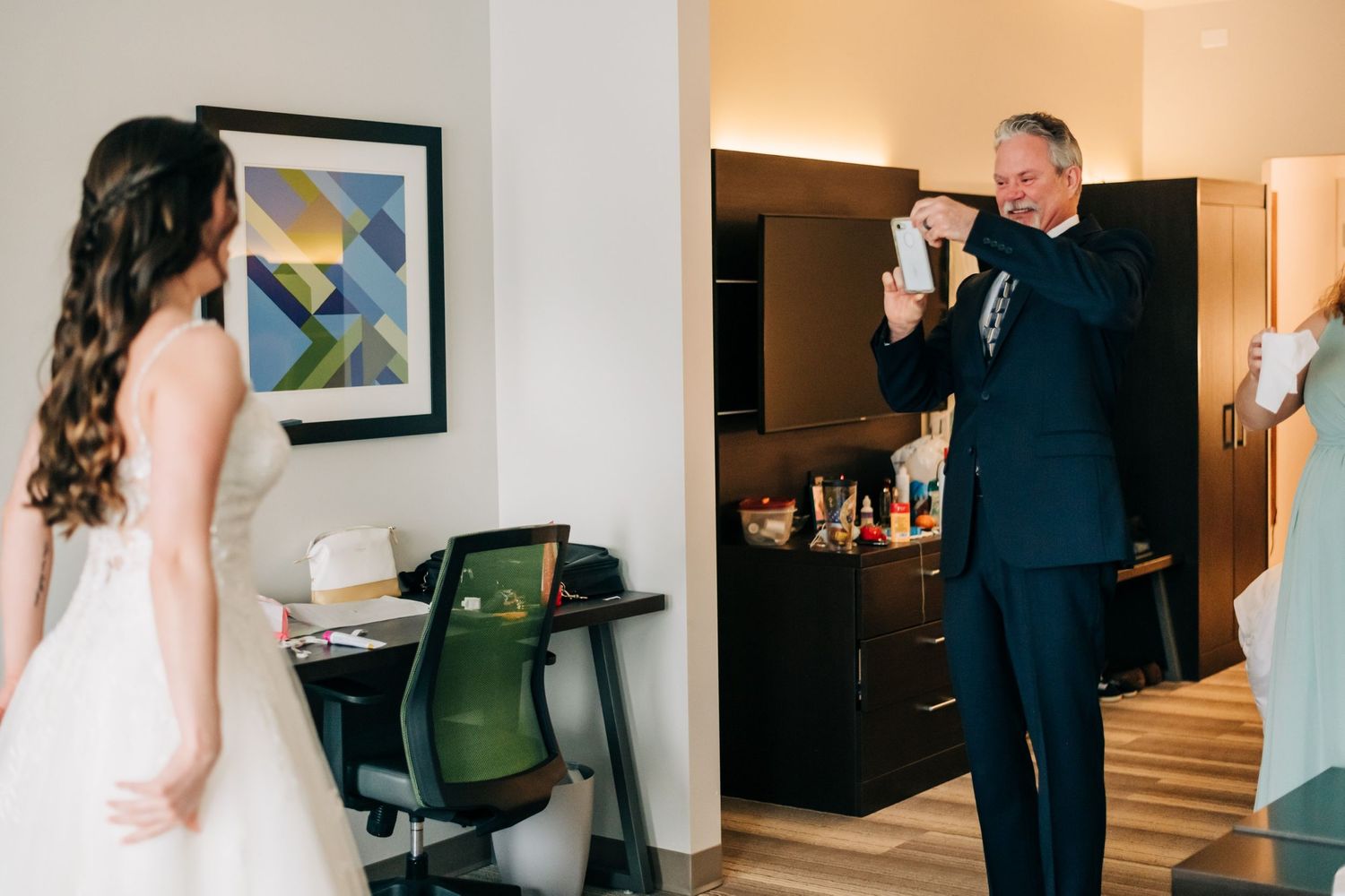 father of the bride taking cell phone photo of bride