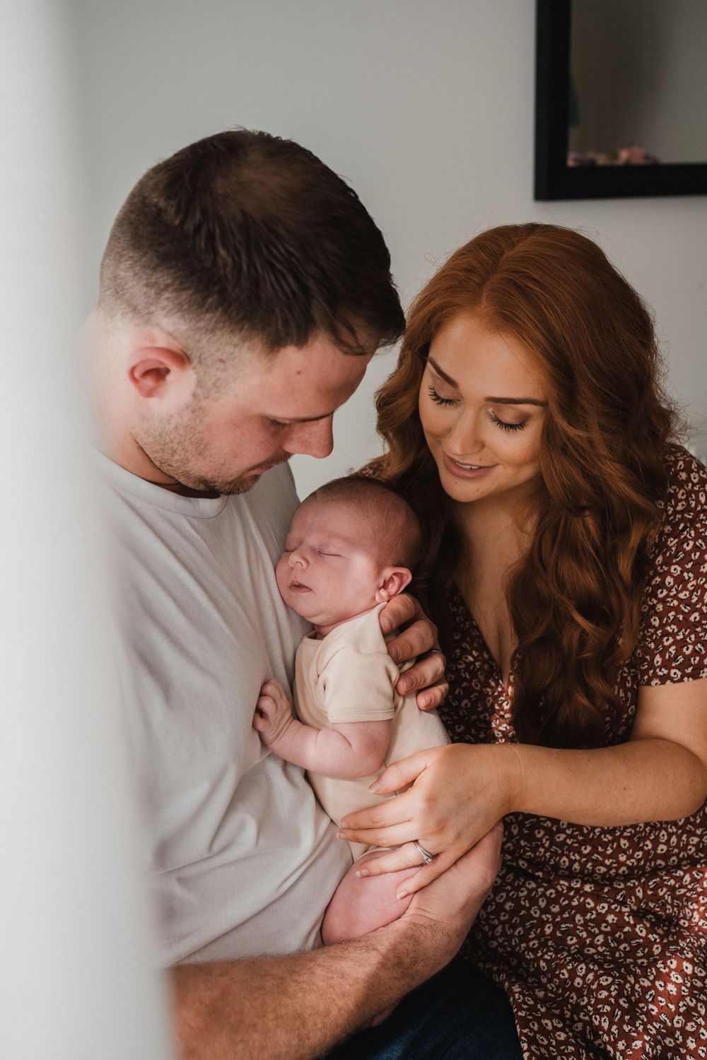 new parents cuddling up to their newborn baby