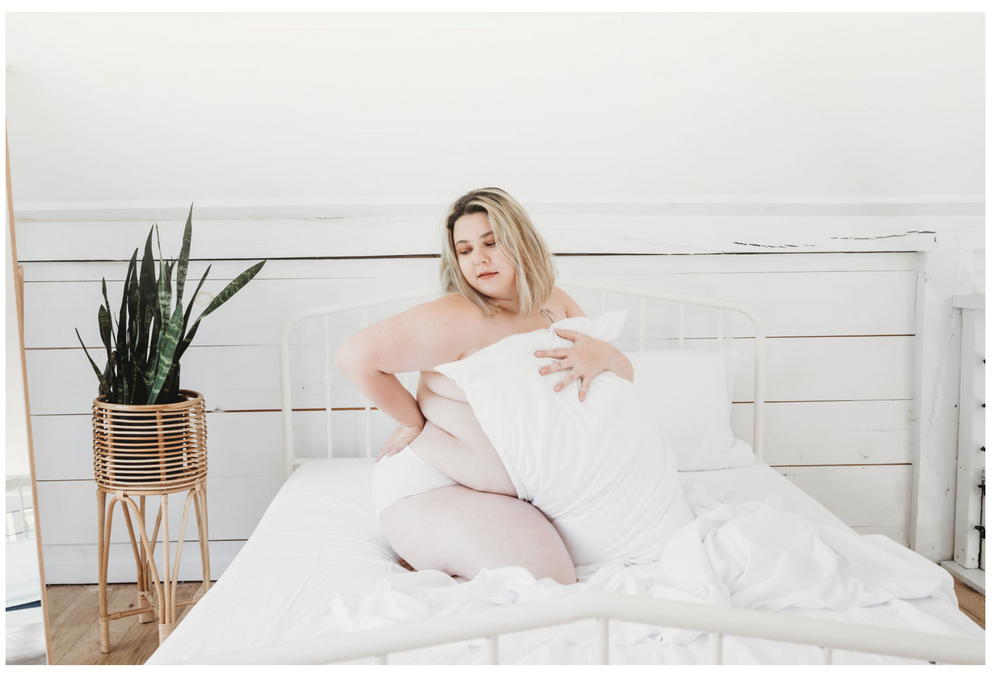 Minimalist white bedroom interior with houseplant and natural decor elements.
