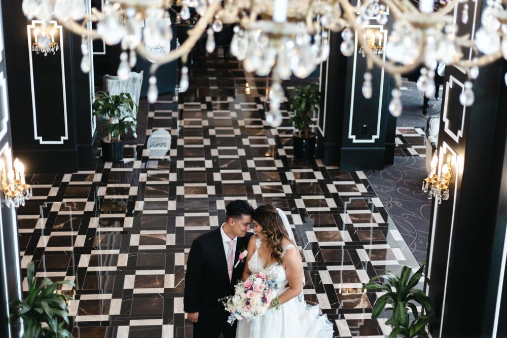 A wedding ceremony venue with geometric flooring and crystal chandeliers overhead.