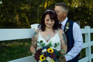 bride and groom by fence