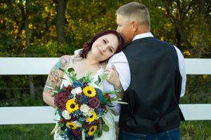 bride and groom by fence
