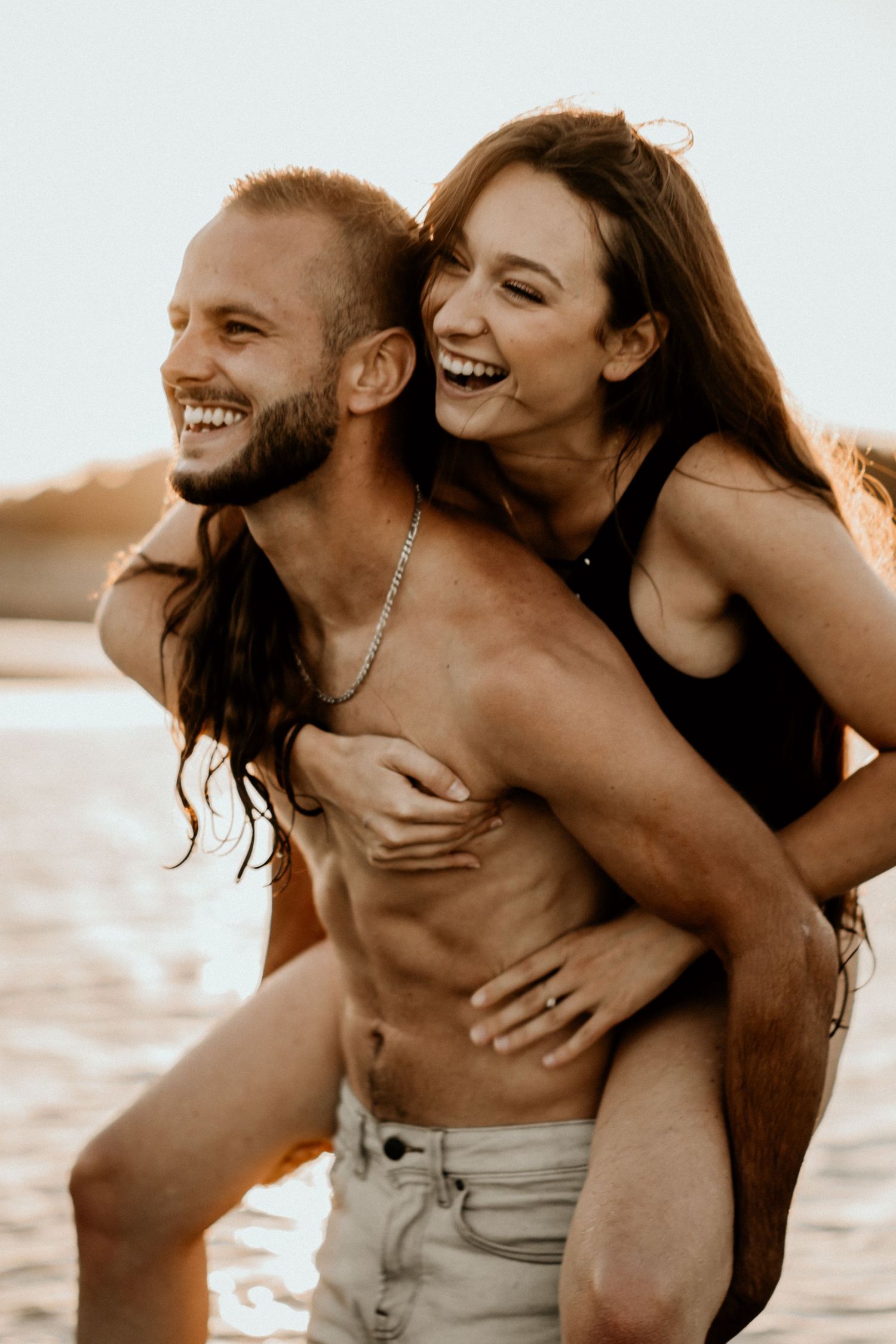 Couple de jeunes amoureux en maillot de bain au bord de l'eau