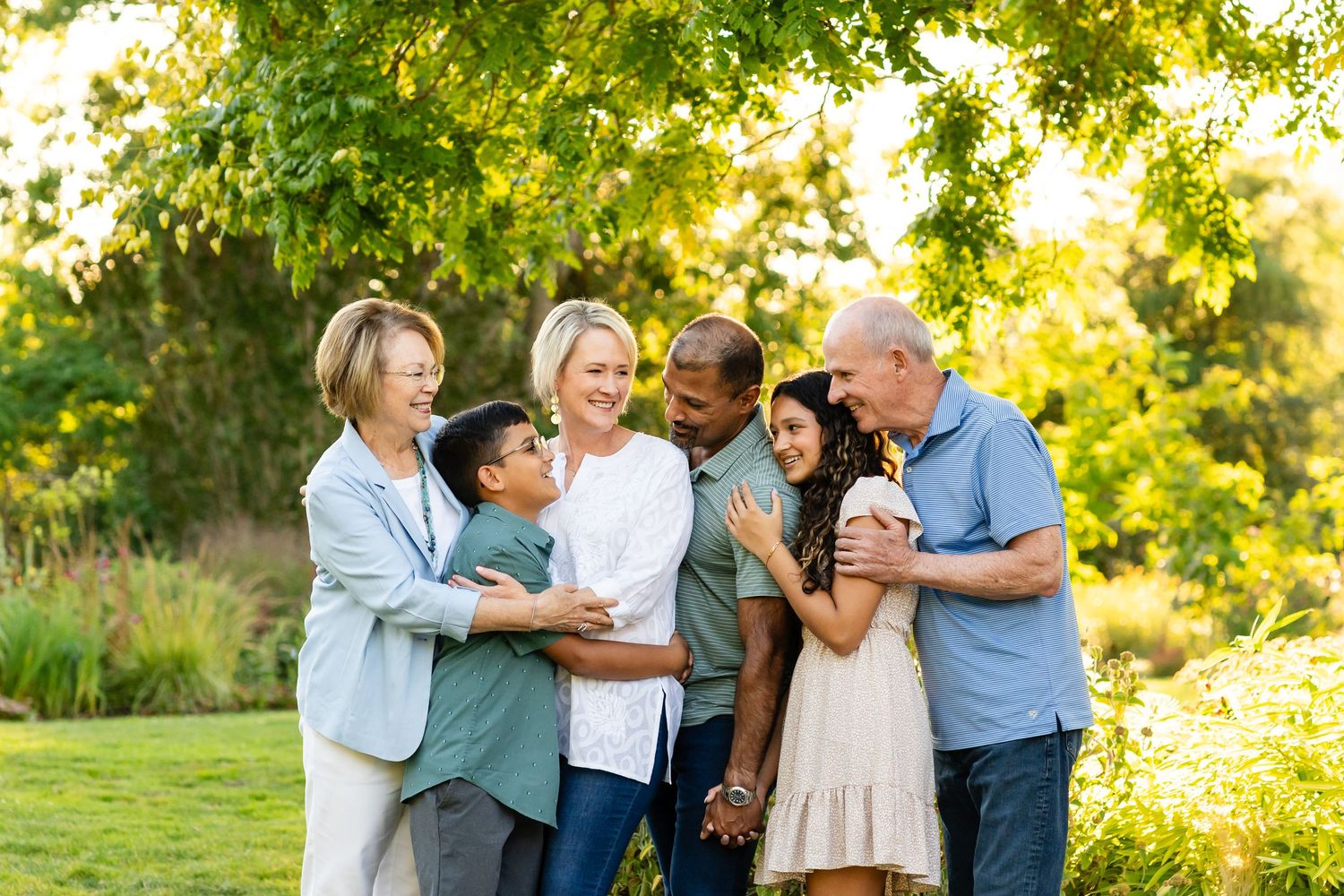 Extended family hugging at sunset in Bellevue Botanical Garden.