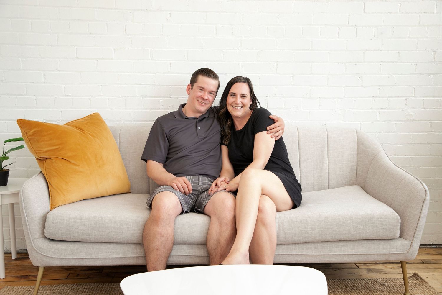 A couple sitting on a couch all cuddled up together