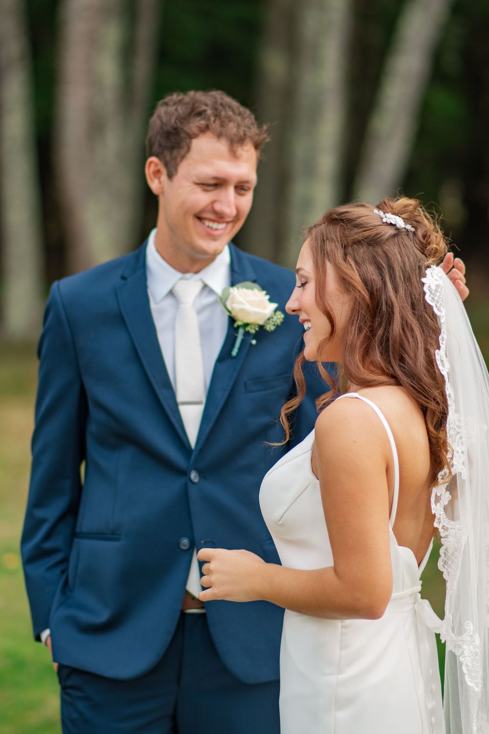 A bride and groom share a joyful moment together in their wedding attire.