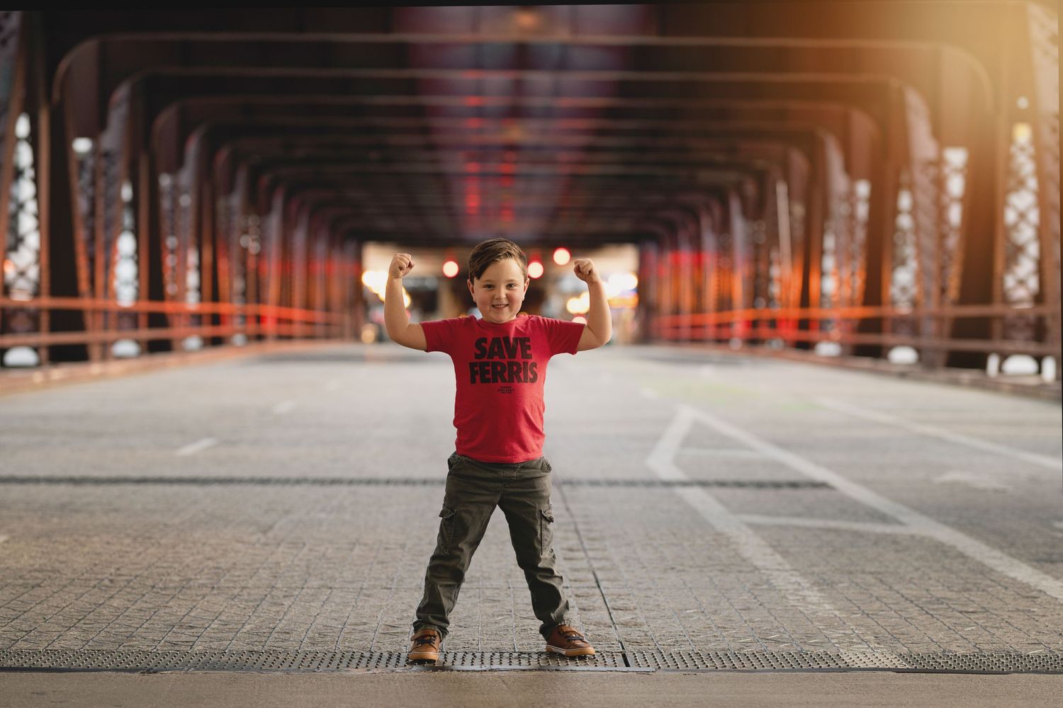 Small figure in red shirt silhouetted against dramatic symmetrical urban bridge architecture with red lighting.