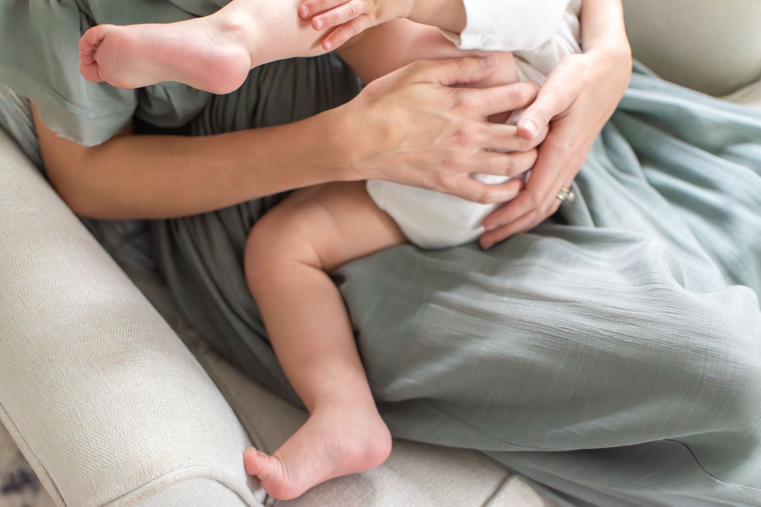 A mother holds her baby as he nurses for comfort in his comfortable nursery.