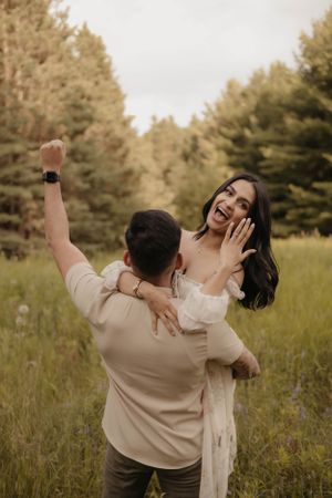 Joyful moment captured as couple celebrates in a golden meadow.