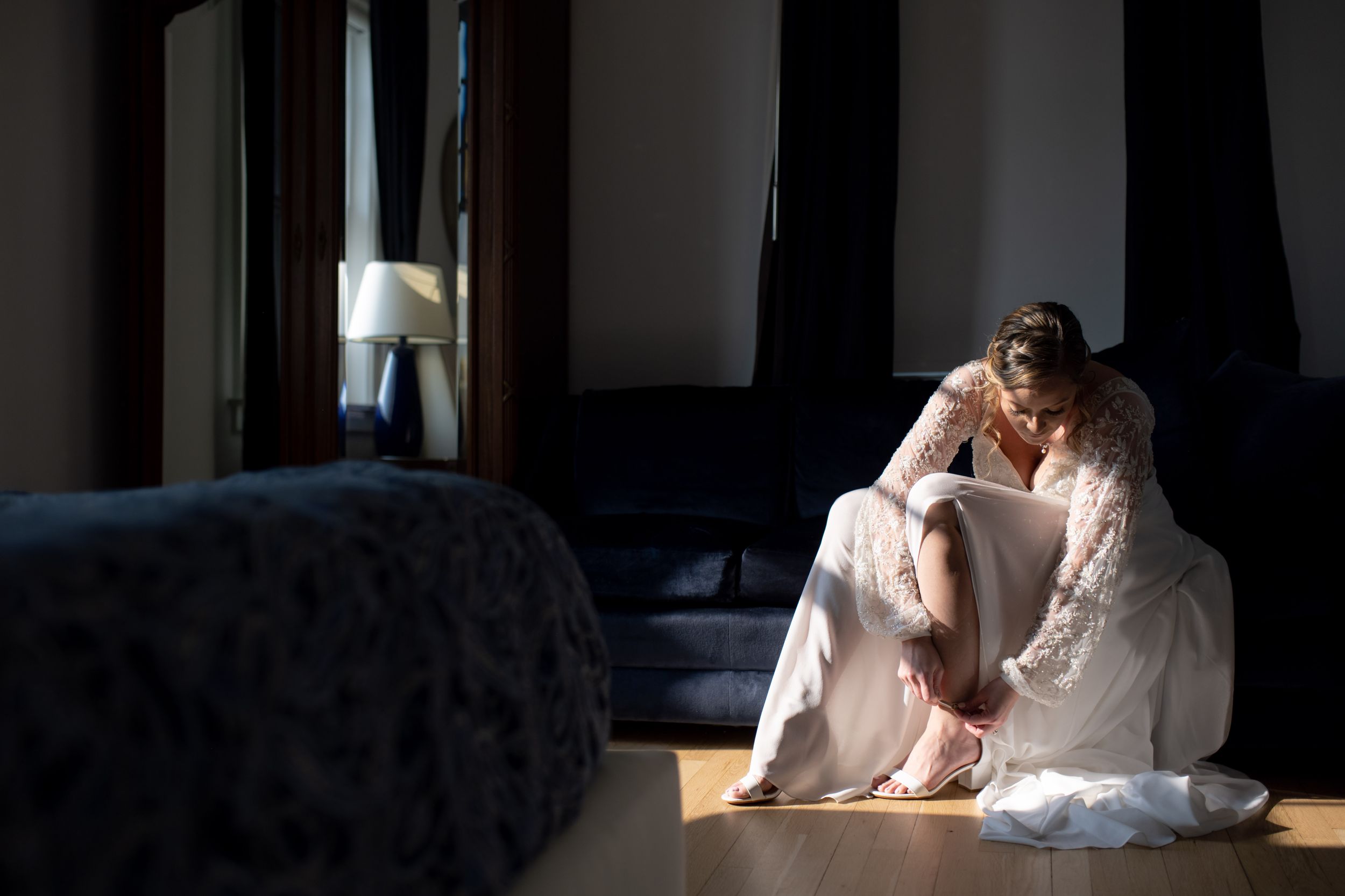 Atmospheric portrait of figure in flowing dress by window light.