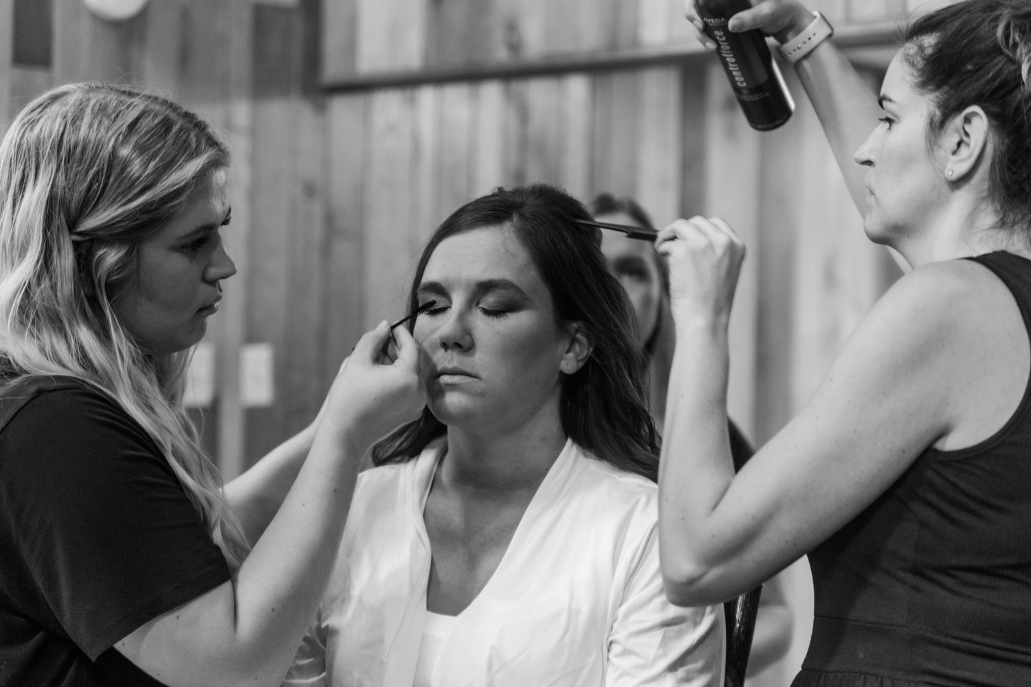 Black and white series of wedding preparation shots showing makeup application.