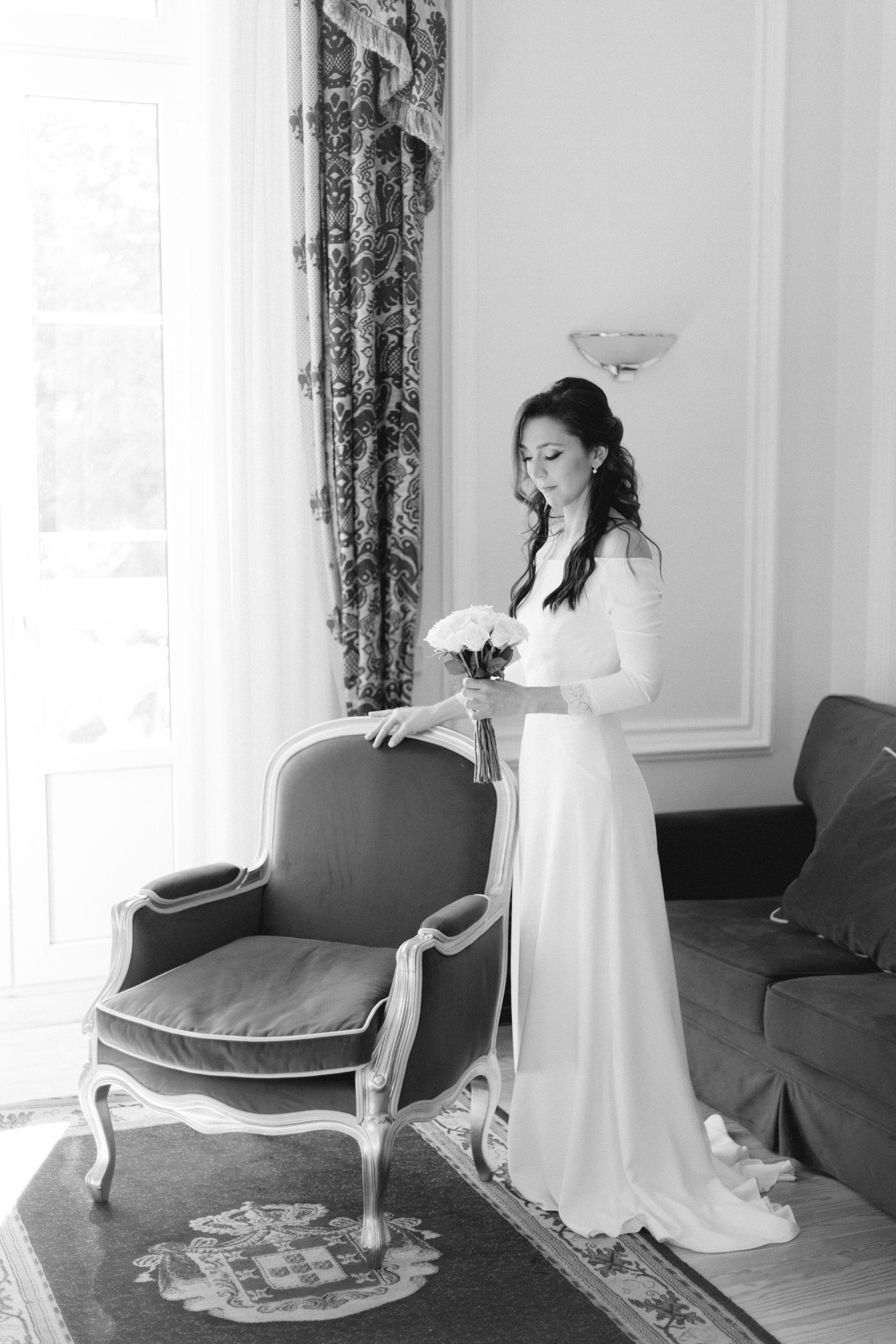 noiva elegante junto de cadeirão no seu quarto no hotel quinta das lágrimas em coimbra