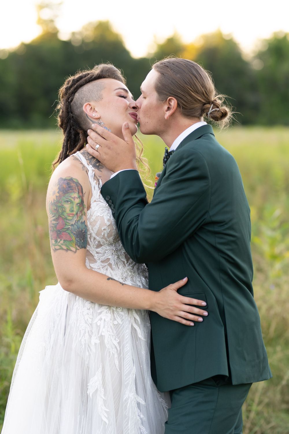 Intimate wedding portrait of couple embracing in a golden sunset field.