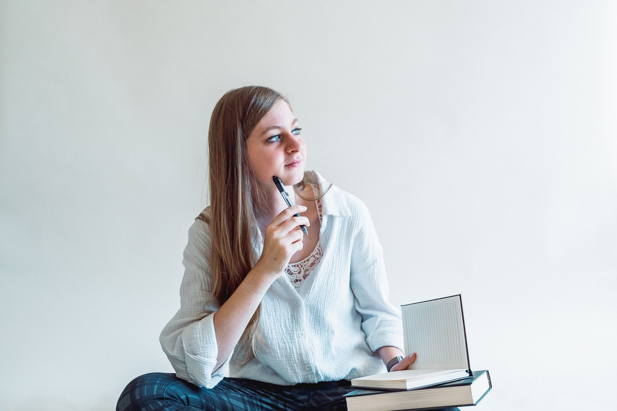 Woman holding a book, journal, and pen while thinking in Phoenix, Arizona