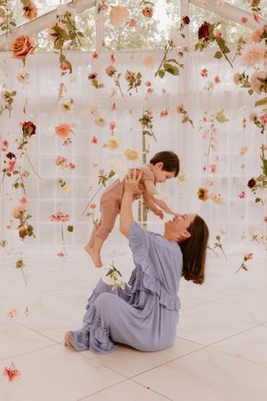 Dreamy floral studio setting with hanging roses and delicate lighting.