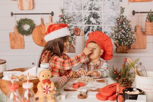 A festive holiday baking scene with Christmas decorations and gingerbread cookies.