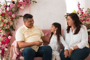 Family portrait setting with pink florals and white archway background.