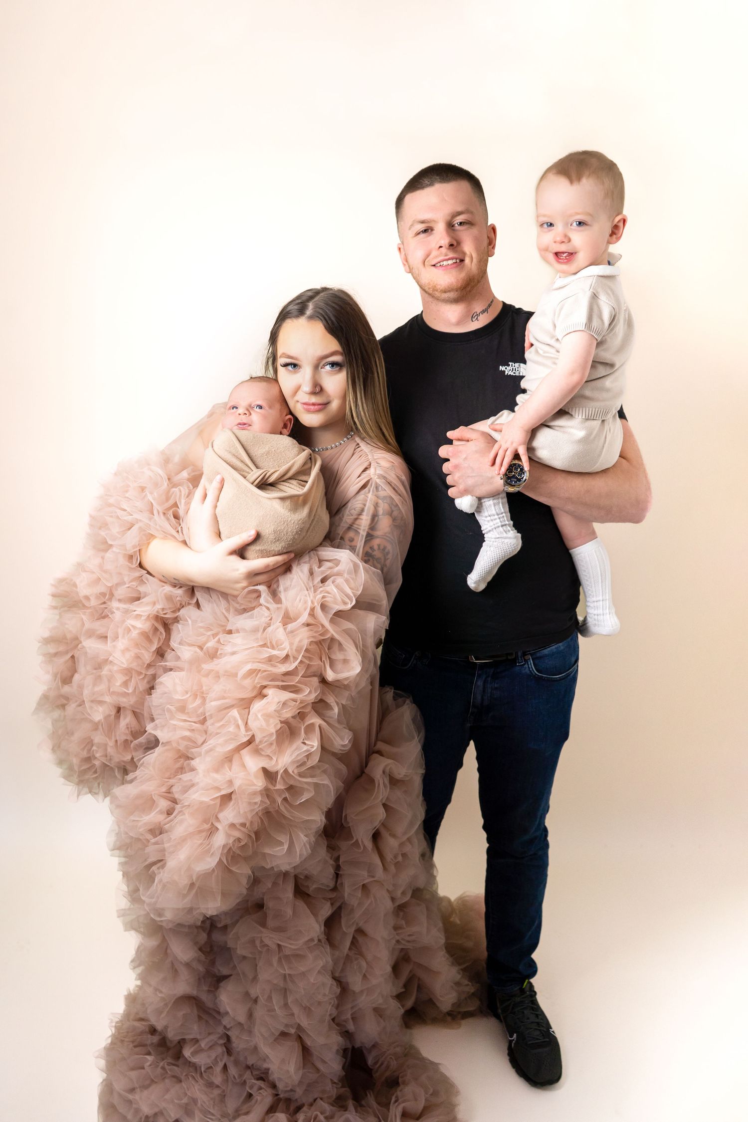 Family photo with newborn, toddler, mum and dad, with mum wearing luxury gown, at newborn photoshoot in Doncaster.