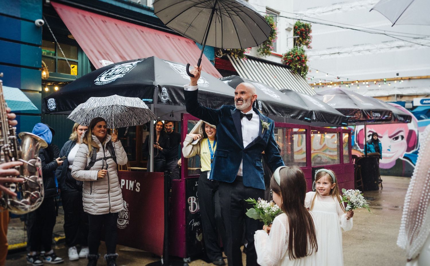 A lively street celebration with umbrellas, musical instruments, and festive atmosphere.