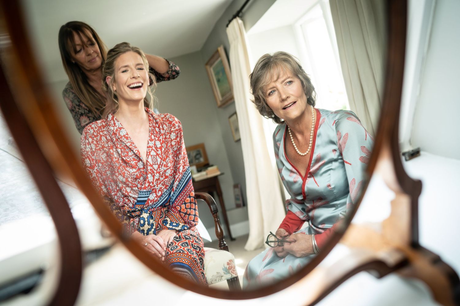 Mother and Chelsea bride reflected in antique dressing mirror Wedding Preparation hero image