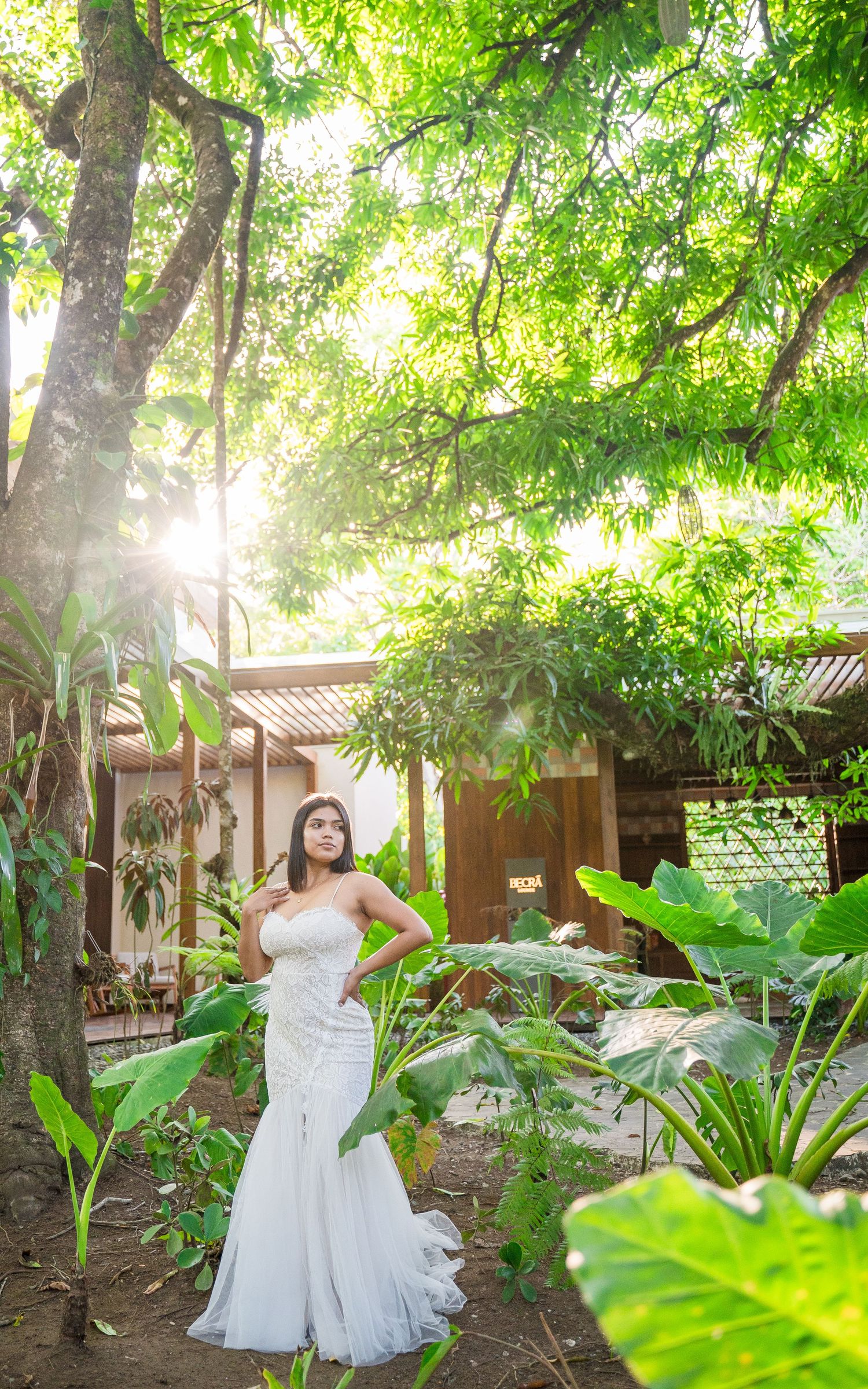 The bride poses in the center of a verdant, green-filled courtyard, Botanika Osa Peninsula