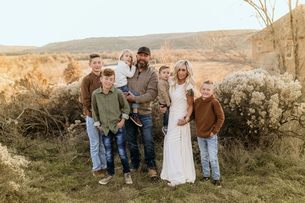 Group portrait in rustic outdoor setting with desert hills in background.