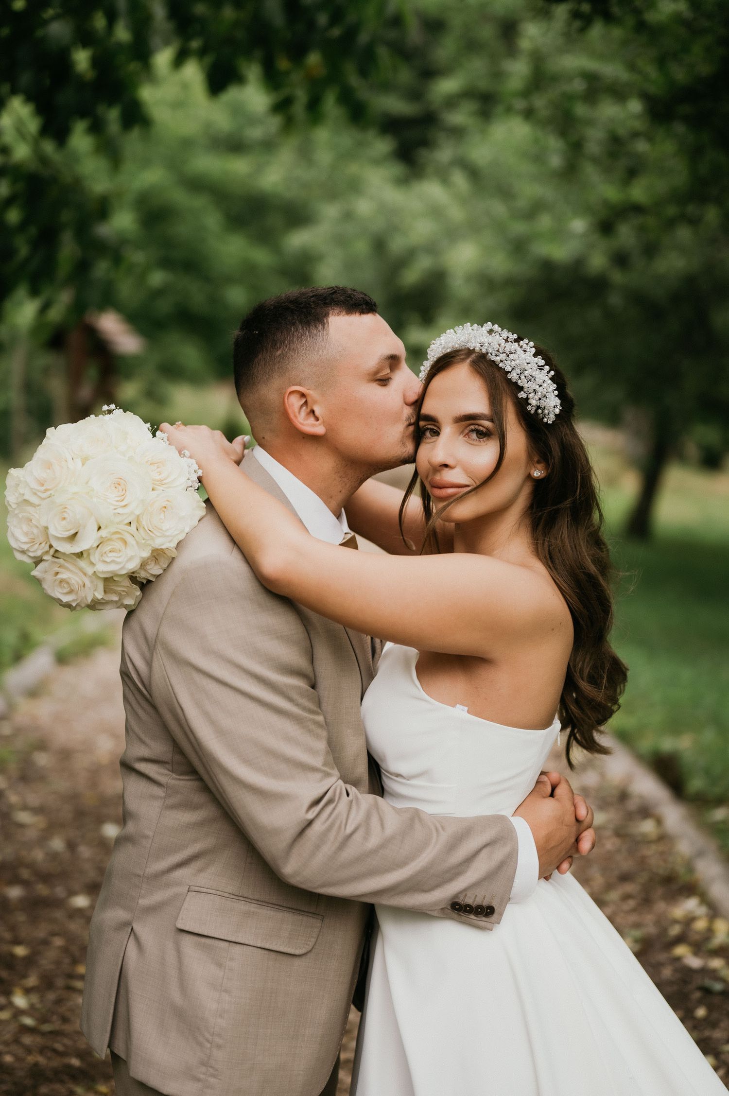 Romantic moment between newlyweds as they embrace in a garden setting.